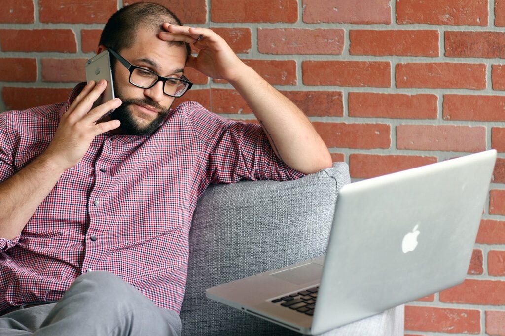 man on telephone in front of laptop trying to sell this timeshare