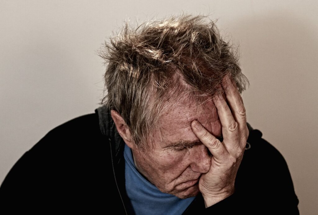 man holding his hand to his head in disappointment because he signed a timeshare contract